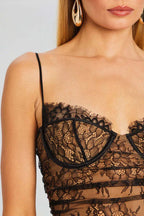 Close-up of the bodice of a black lace dress, showing the sweetheart neckline and intricate floral lace pattern.