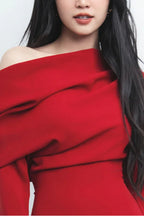 Close-up of the draped neckline and off-the-shoulder design of a red dress.