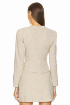 Back view of a beige blazer dress with a structured silhouette.