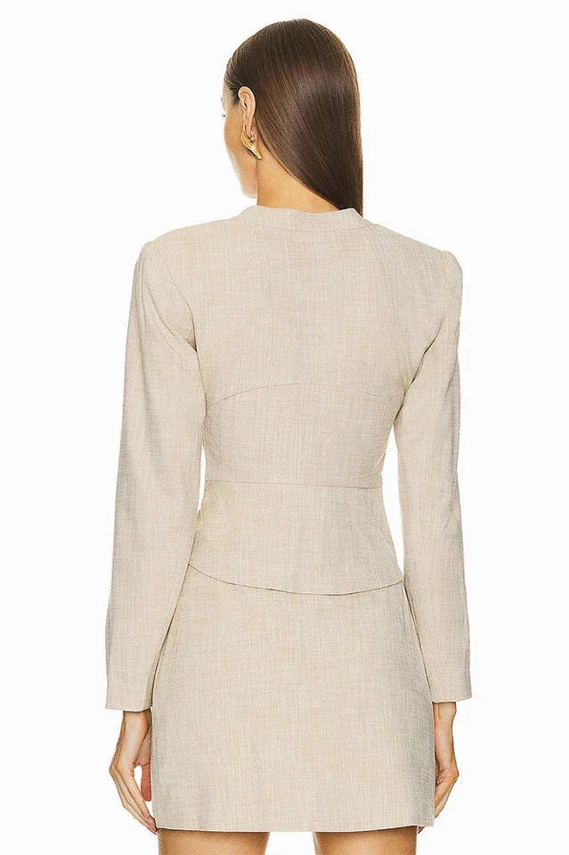 Back view of a beige blazer dress with a structured silhouette.