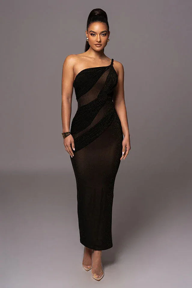 Woman wearing a long, one-shoulder, black dress with ruching and sheer panels.
