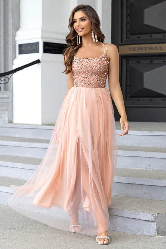 woman in a peach sequined and tulle evening gown with a high slit Main image