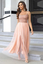 woman in a peach sequined and tulle evening gown with a high slit