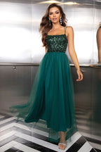 woman in a dark green sequined and tulle evening gown