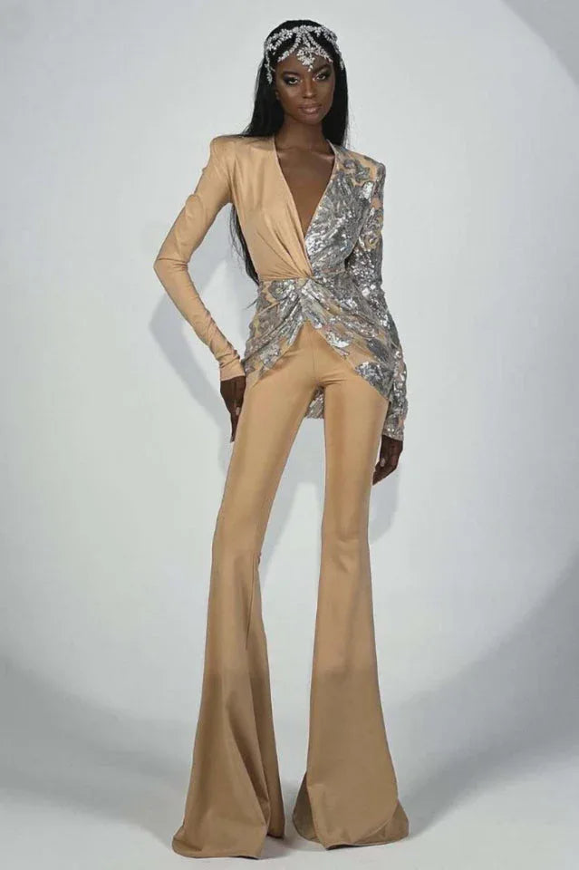 Woman wearing a tan and silver sequined jumpsuit with flared legs and a deep V-neck, accessorized with a jeweled headpiece.
