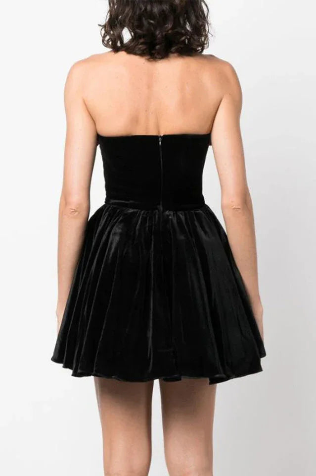 Back view of a black velvet strapless mini dress with a full skirt.
