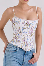 Front view of a woman in a floral print corset top with lace trim and adjustable straps.