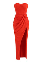 Front view of the strapless orange ruched gown with a high slit
