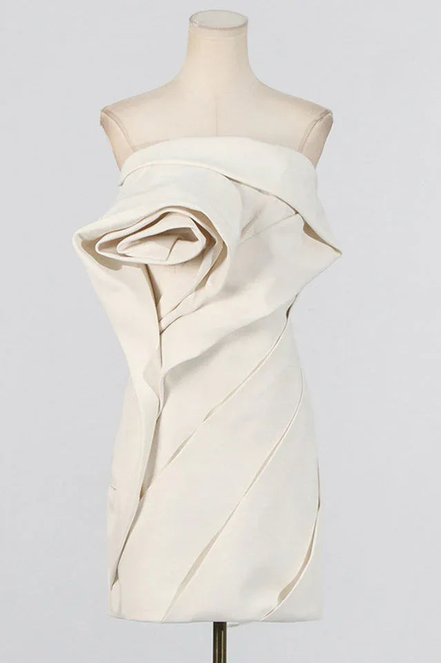 Mannequin displaying an off-white strapless dress with a large rose detail on the bodice and pleated skirt.