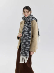 Close-up of a woman wearing a leopard print scarf draped over a tan blazer