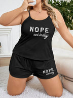 Woman in a black pajama set with 'NOPE. not today.' graphic print, posing on a rug.