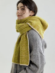 Close-up profile of a model wearing a lime green chunky knit scarf with contrasting trim.