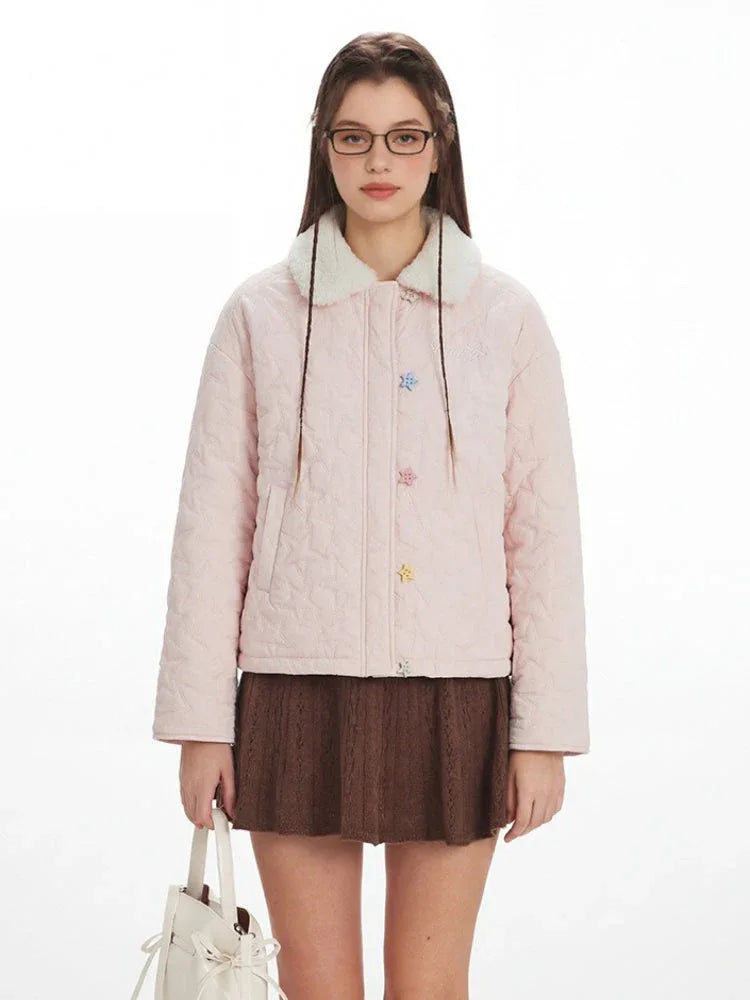 Close-up of a model wearing a pink quilted jacket with a faux fur collar and colorful star buttons.
