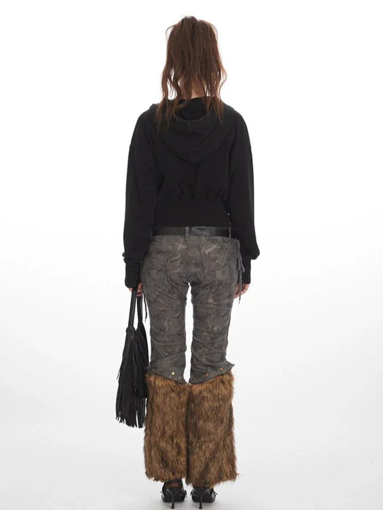 Back view of a woman wearing a black cropped hooded jacket, patterned pants, and brown fur leg warmers. Secondary image