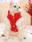 Cat wearing a red Chinese-style vest with white trim, looking forward.