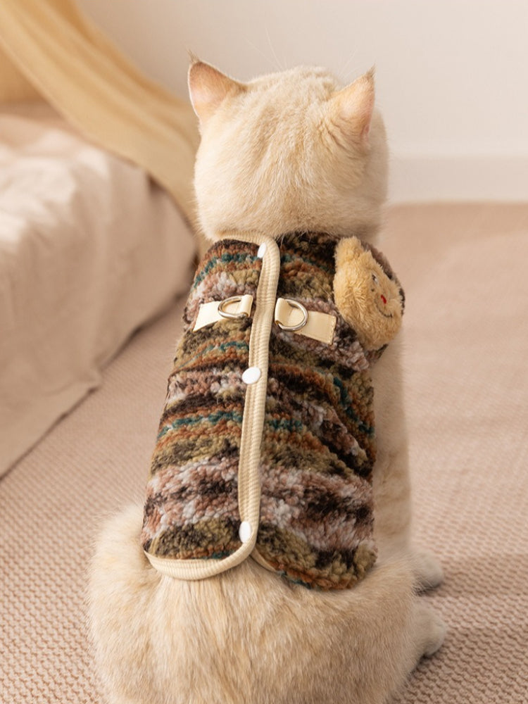 The rear view of a cream-colored cat dressed in a textured camouflage fleece vest with functional closures.