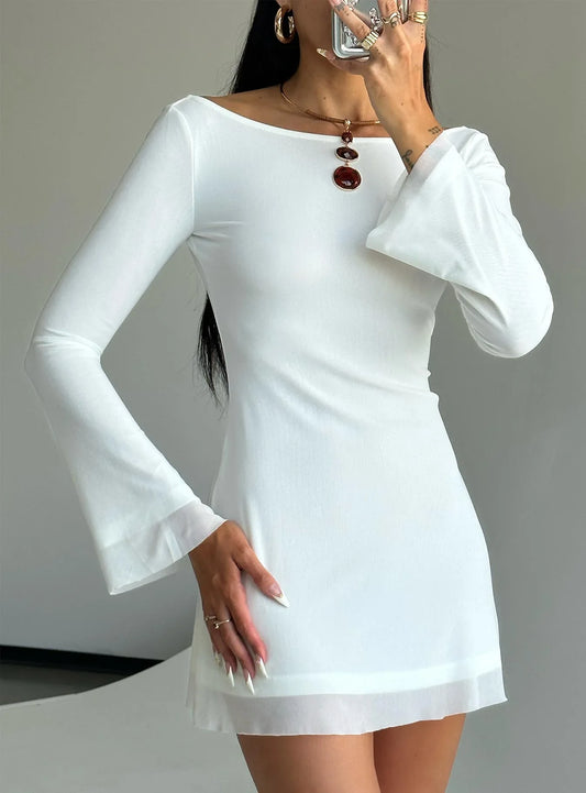 Model wearing a white long-sleeve mini dress with flared sleeves and a sheer hem.