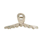 A cream-colored claw clip with colorful gemstones