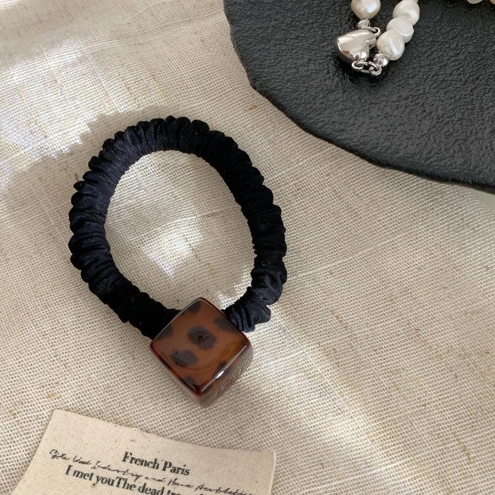 Minimalist hair tie with a square acetate bead in a leopard or tortoise pattern - View 7 | TEVQA