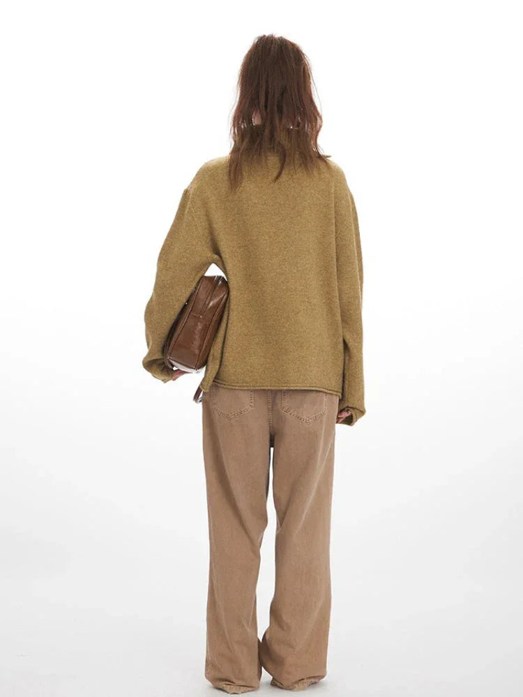 Model wearing a tan oversized knit sweater with wide collar and button detail, paired with tan wide-leg pants, back view. Secondary image