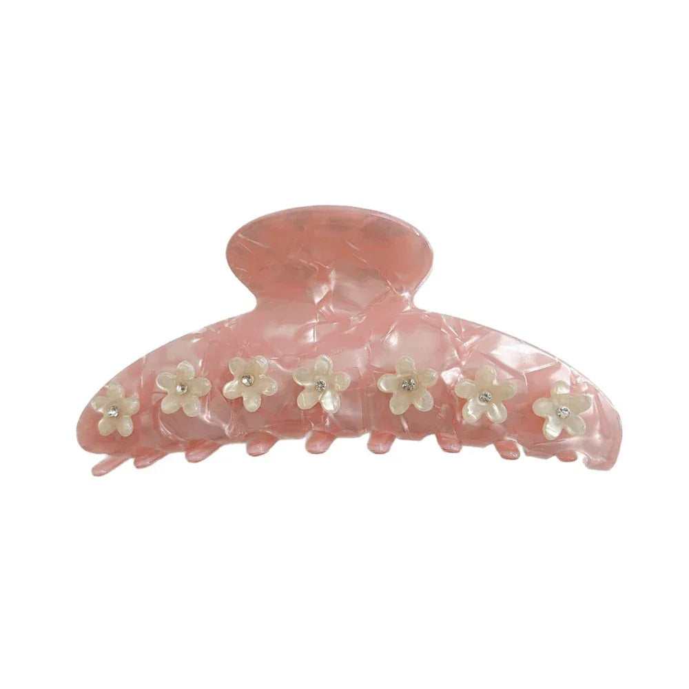 Pink marbled claw clip with white floral accents and clear gemstones.
