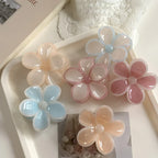 flower claw clips on a white tray with a pearl necklace and book in the background