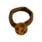 Brown fabric hair tie with a round, leopard print charm.