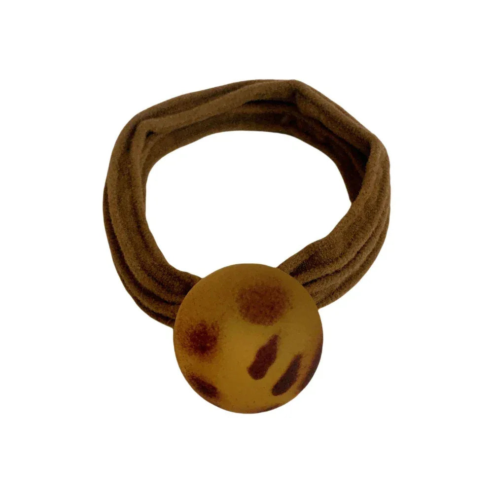 Brown fabric hair tie with a round, leopard print charm.