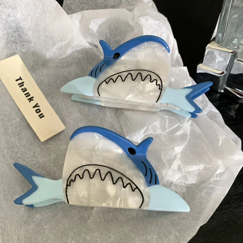 Two blue and white shark hair clips with a 'Thank You' tag