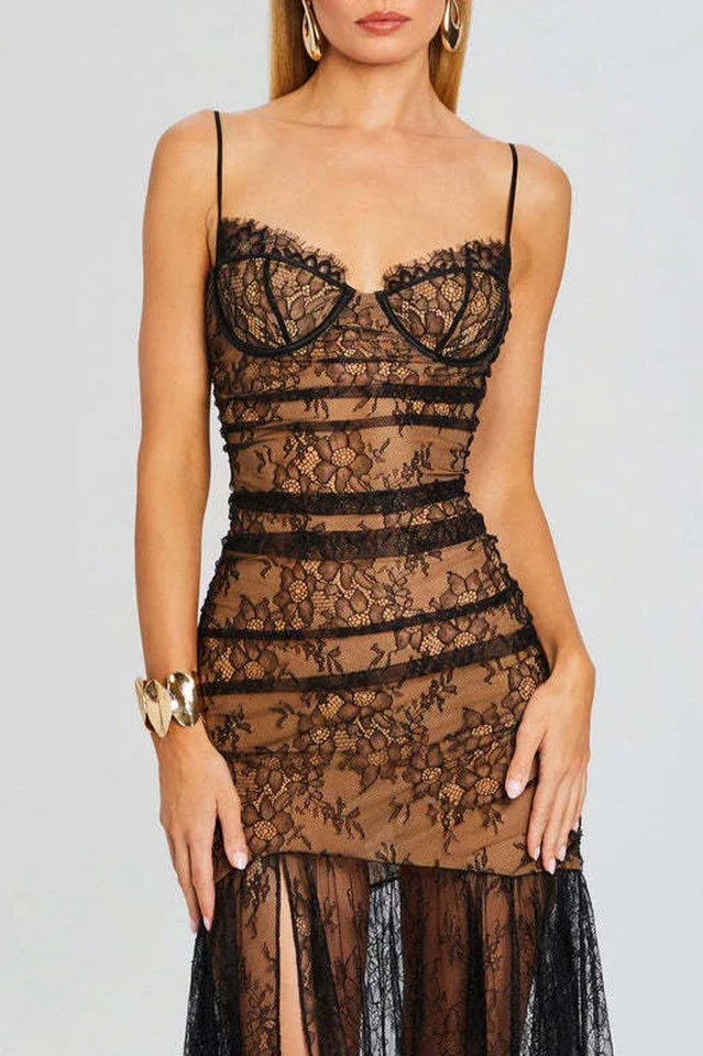 Front view of a woman wearing a black lace evening dress with a sweetheart neckline and a high slit.
