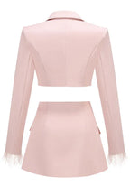 Pink cropped blazer and asymmetrical skirt with feather trim laid flat, back view