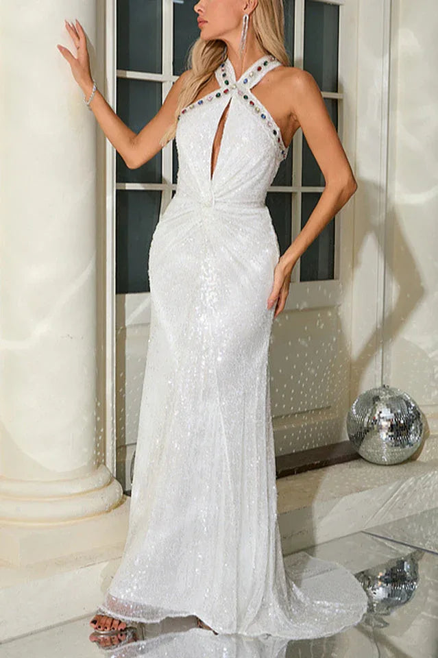 Model posing in a shimmering white sequined gown for a formal event.
