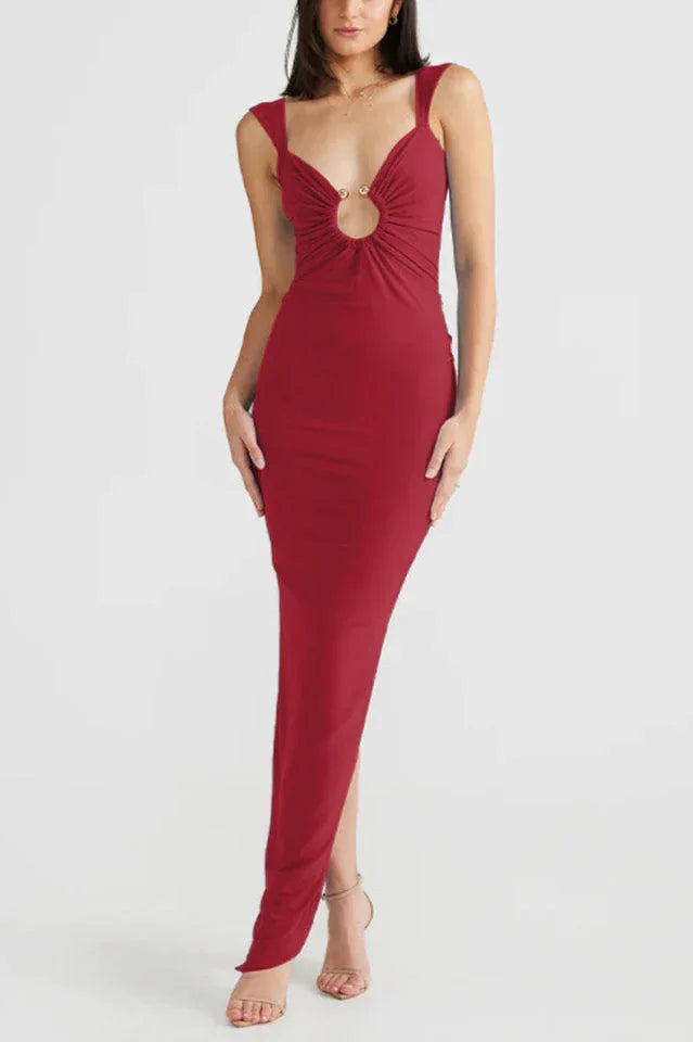 Woman wearing a long red sleeveless dress with a deep V-neck and a cutout detail at the bust.