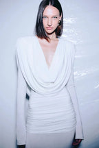 Close-up of the draped neckline and ruched waist of a white gown.