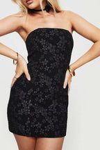 woman wearing a black strapless floral jacquard mini dress