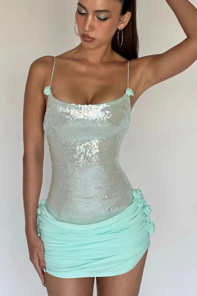 Front view close-up of a woman in a light blue sequined dress with ruched detailing and floral appliques.