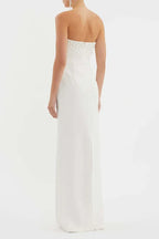 Back view of a woman in a white strapless pearl-embellished column gown