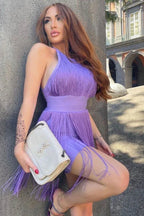 Woman with red hair wearing a purple fringe dress and holding a white handbag