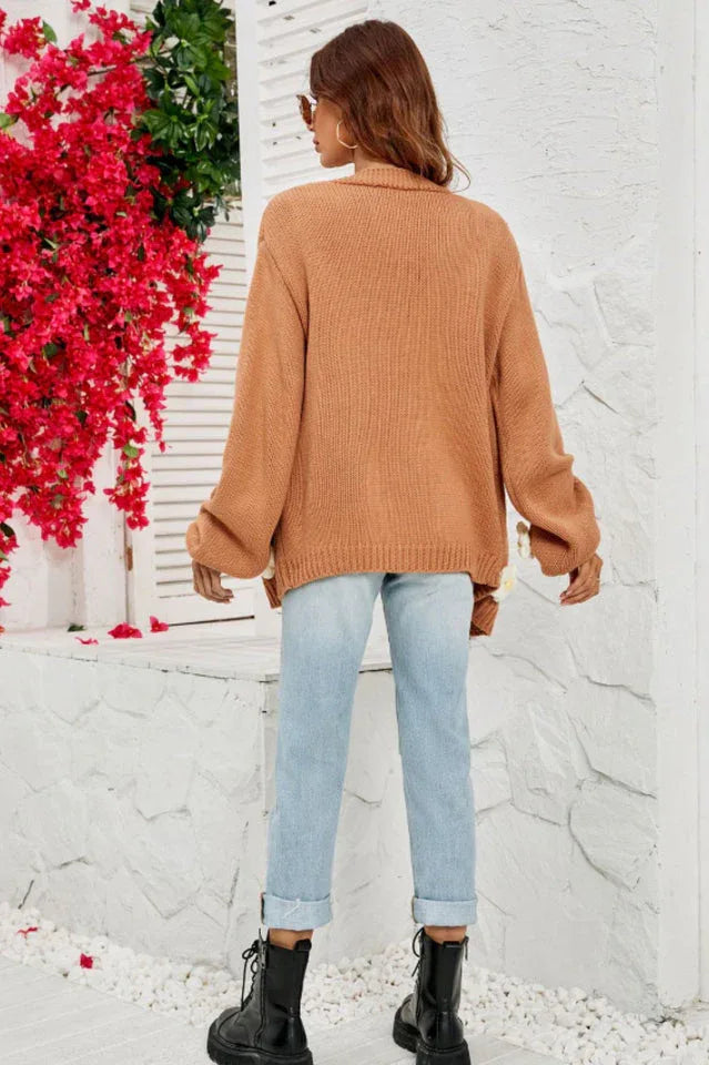 Back view of a woman wearing a brown floral cardigan and light wash ripped jeans.