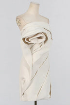 Close-up of an off-white strapless dress with a sculpted rose bodice on a mannequin.