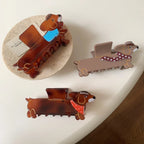 Three dachshund hair claw clips in various colors and scarf patterns