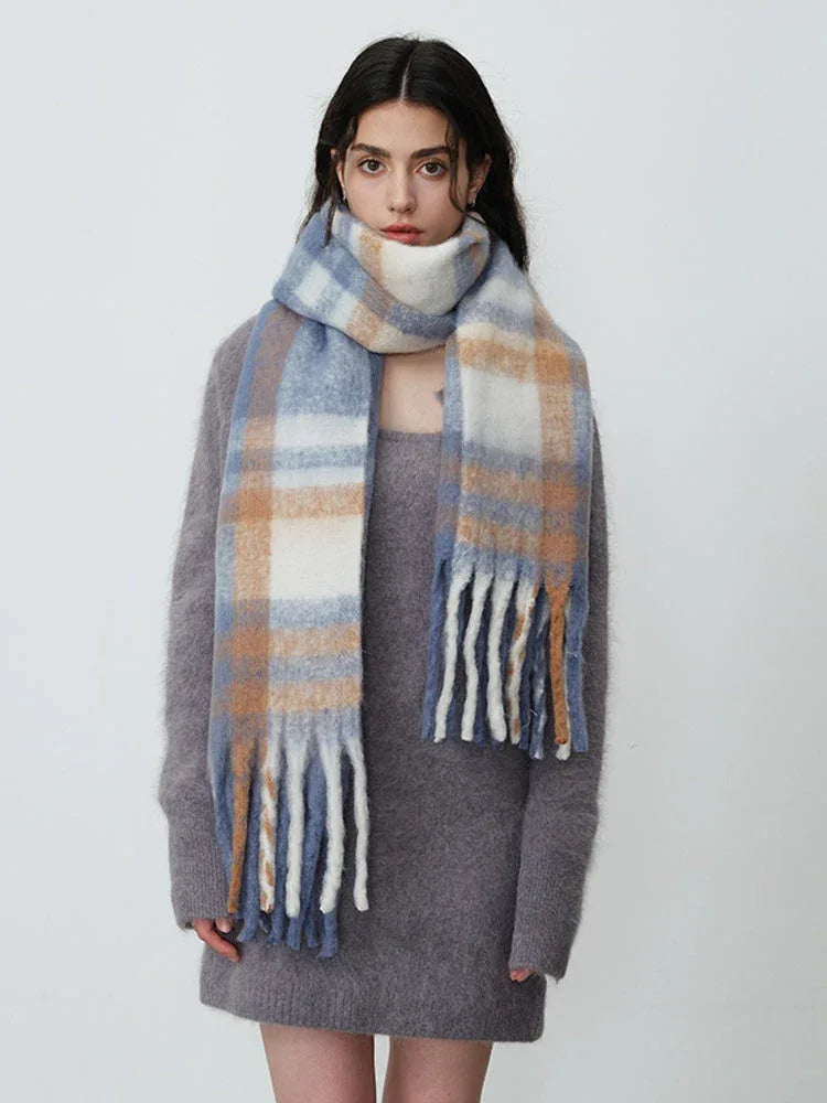 Woman wearing a grey knit dress and a plaid scarf