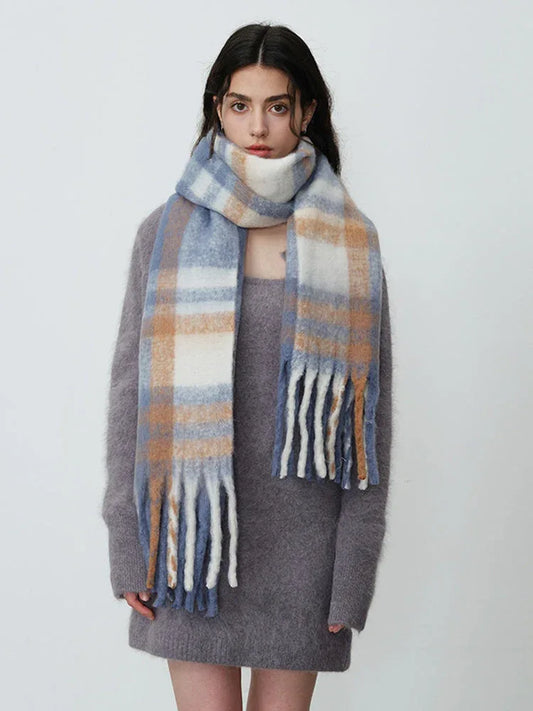 Woman wearing a grey knit dress and a plaid scarf
