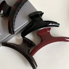 close-up of four hair claw clips in black, dark brown, burgundy, and tortoiseshell
