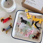 Various acrylic animal charms arranged on a white tray