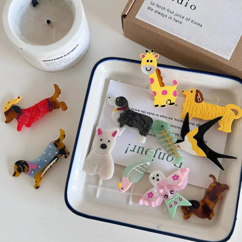 Various acrylic animal charms arranged on a white tray