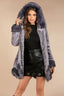 Woman wearing a grey faux fur coat with a hood and black top