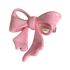 A pink bow-shaped hair clip with a marbled swirl pattern.