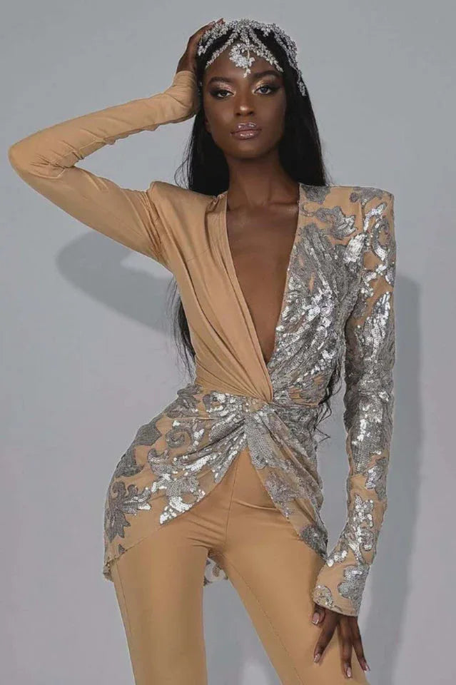 Elegant woman showcasing a high-fashion jumpsuit with a striking asymmetrical sequined design and wide-leg pants.