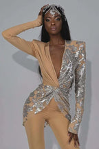 Elegant woman showcasing a high-fashion jumpsuit with a striking asymmetrical sequined design and wide-leg pants.